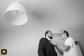 In a small village in Haute-Garonne at the groom's parents' home, the father of the groom shares an intimate pre-ceremony moment, carefully adjusting his son's tie knot before the wedding.